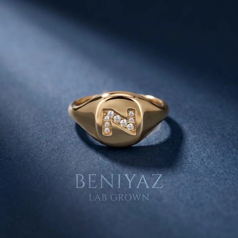 A polished personalized signet ring featuring a diamond-accent initial for a clean, modern statement look.